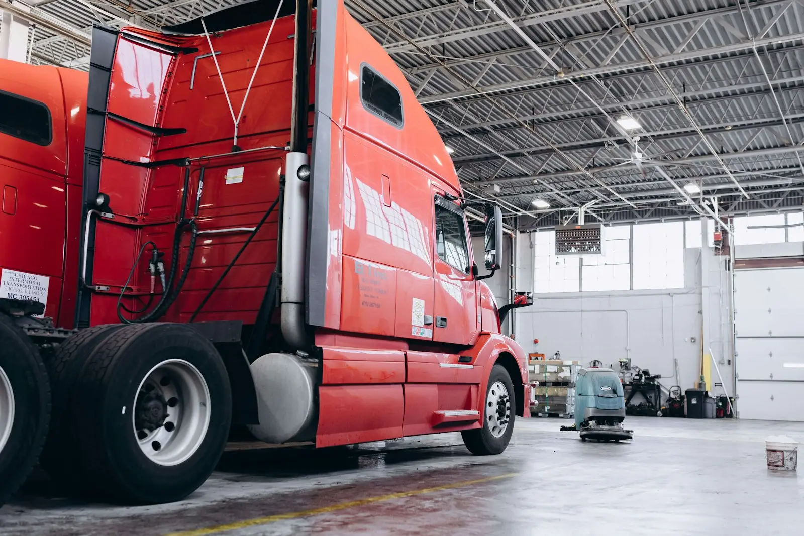 Czerwony ciągnik siodłowy stojący w hali warsztatowej